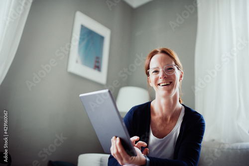 Rothaarige Frau arbeitet mit ihrem iPad 