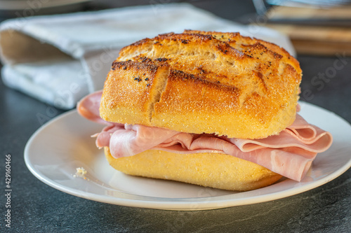 German Pepper and salt brötchen with ham on a plate