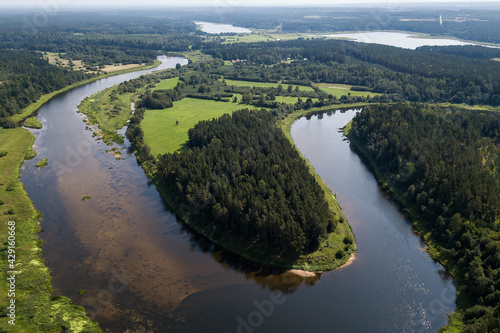 Aerial view of beautiful river bend and forests on a sunny summer day. 