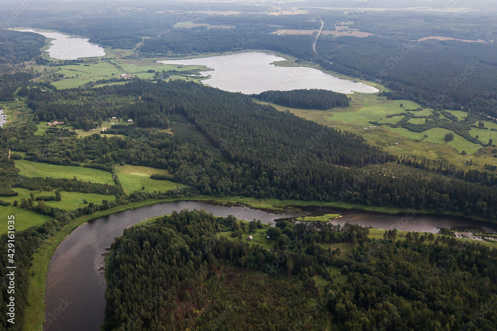 Aerial view of river bend and forests on a sunny summer day. 