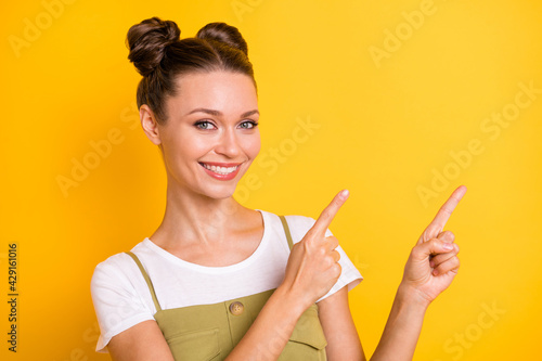 Portrait of optimistic brunette nice lady point empty space wear bright t-shirt isolated on vivid yellow color background