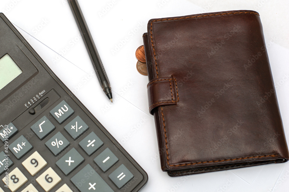 calculator fountain pen and wallet on white sheets of paper on the table calculator fountain pen and wallet on white sheets of paper on the table