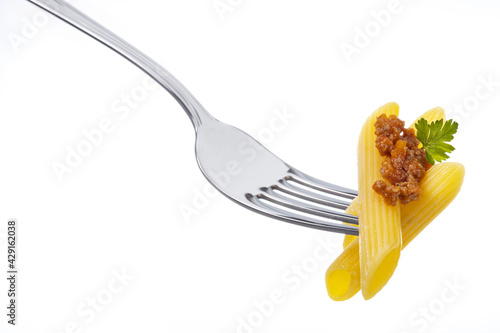 Penne pasta with bolognese meat sauce and parsley leaf on a fork isolated on white background. Eating classic italian cuisine.