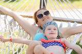 Woman with sunglasses little girl lying on hammock together