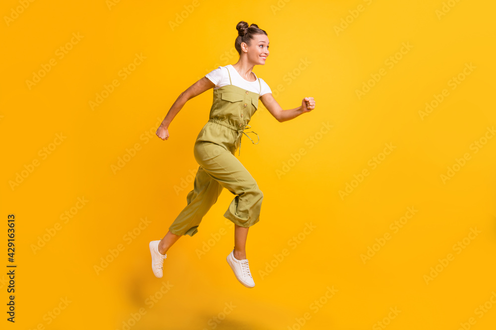 Full length body size view of pretty cheerful active girl jumping running motivation isolated over bright yellow color background
