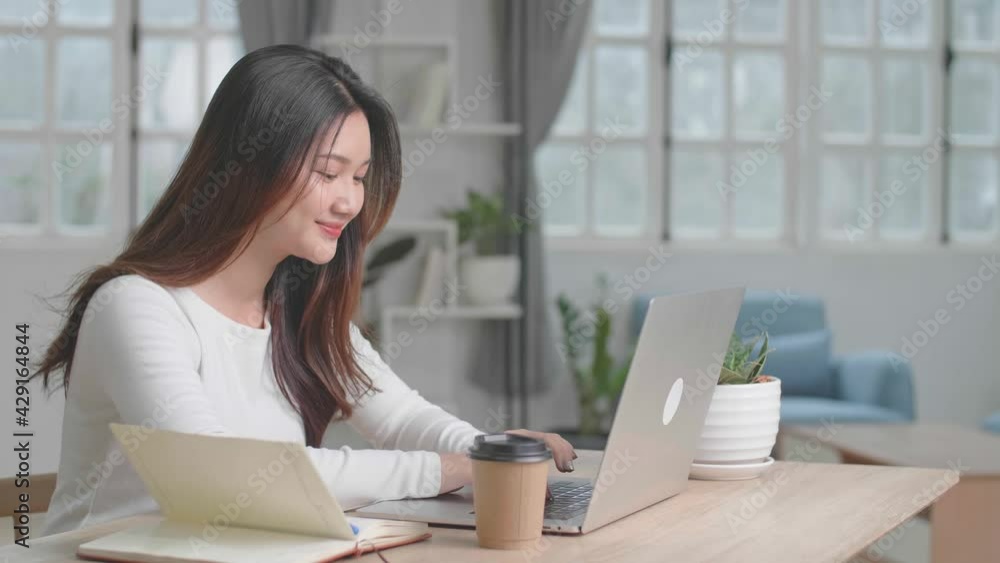 Happy Asian Girl Typing On Computer Keyboard Of A Laptop At Home Happy Asian Girl Typing On Computer Keyboard Of A Laptop At Home