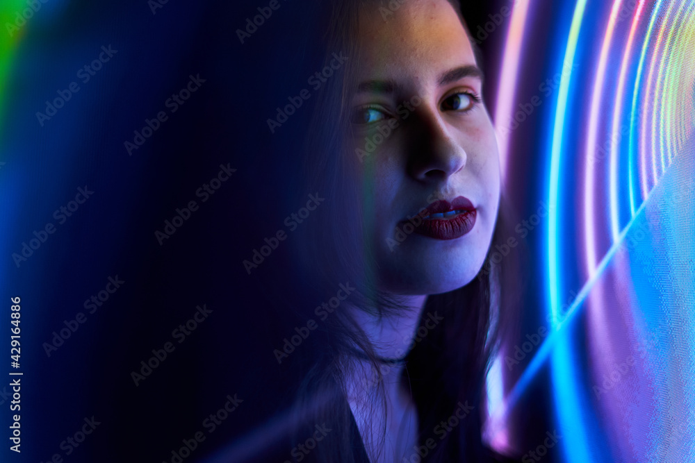 Pretty young woman with fair skin and long hair with colored neon and reflections. teenager with neon signs and reflections of colored neon lights. party woman Pretty young woman with fair skin and long hair with colored neon and reflections. teenager with neon signs and reflections of colored neon lights. party woman