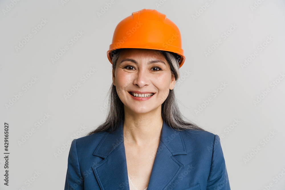 Asian mature woman wearing helmet smiling and looking at camera Asian mature woman wearing helmet smiling and looking at camera