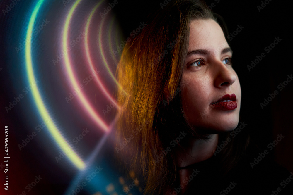 Pretty young woman with fair skin and long hair with colored neon and reflections. teenager with neon signs and reflections of colored neon lights. party woman