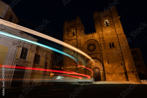 Lisbon city at night. Old town with traffic lights and famous Santa Maria cathedral at night.