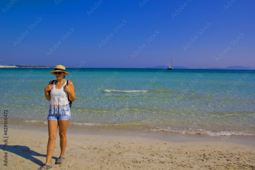 beautiful young woman in a hat on the beach	