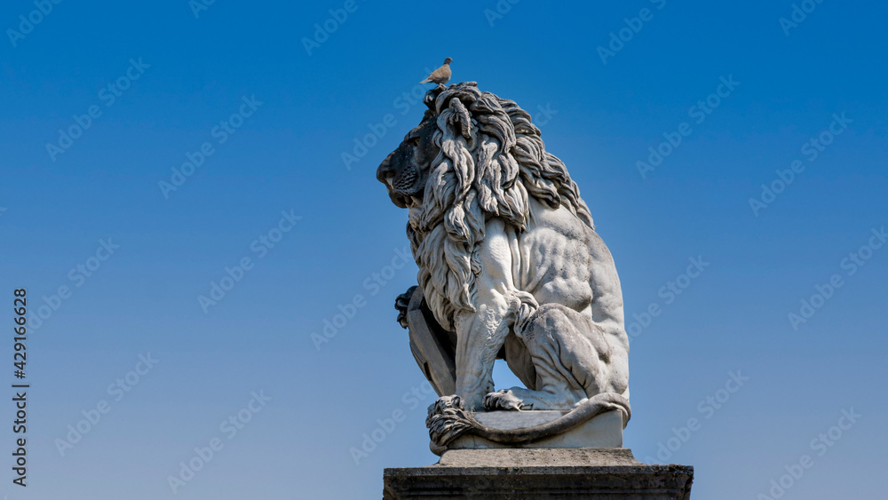Statue of a lion with a dove on his head 