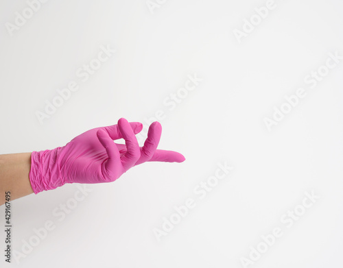 female hand in a pink latex glove on a white background, palm open