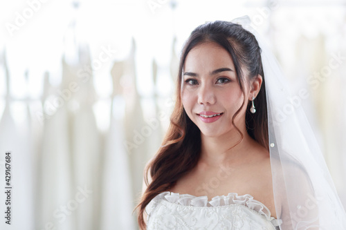 The bride smiling standing and held her hand on her waist. Asian woman in white lace wedding dress in background. Concept the most beautiful and best day. Free Download The bride smiling standing and held her hand on her waist. Asian woman in white lace wedding dress in background. Concept the most beautiful and best day. - GFXLoad