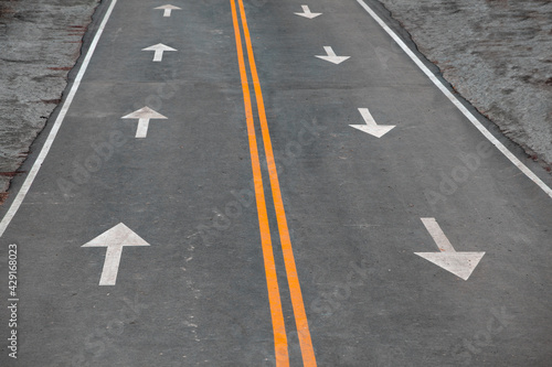 Asphalt Road with Two Yellow Dividing Lanes and Arrows Drawn on the Asphalt Indicating The Direction of Movement. Concept of Traffic Rules, Motivation, Business