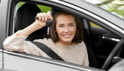 driving, safety and people concept - young woman or female driver sitting in car and showing key © Syda Productions