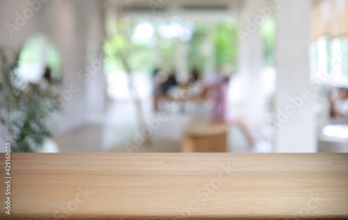 Empty wooden table in front of abstract blurred background of coffee shop . can be used for display or montage your products.Mock up for display of product