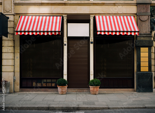 photo of closed and locked clothier or dress outfitter, shop front, impact of the corona virus pandemic 2021 in Germany.