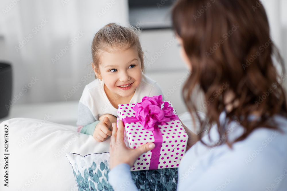 people, family and holidays concept - happy little daughter giving present to her mother at home people, family and holidays concept - happy little daughter giving present to her mother at home