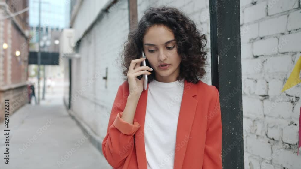 Portrait of girl in elegant clothes chatting on mobile phone outdoors in city street on summer day. Youth lifestyle and modern communication concept. Portrait of girl in elegant clothes chatting on mobile phone outdoors in city street on summer day. Youth lifestyle and modern communication concept.
