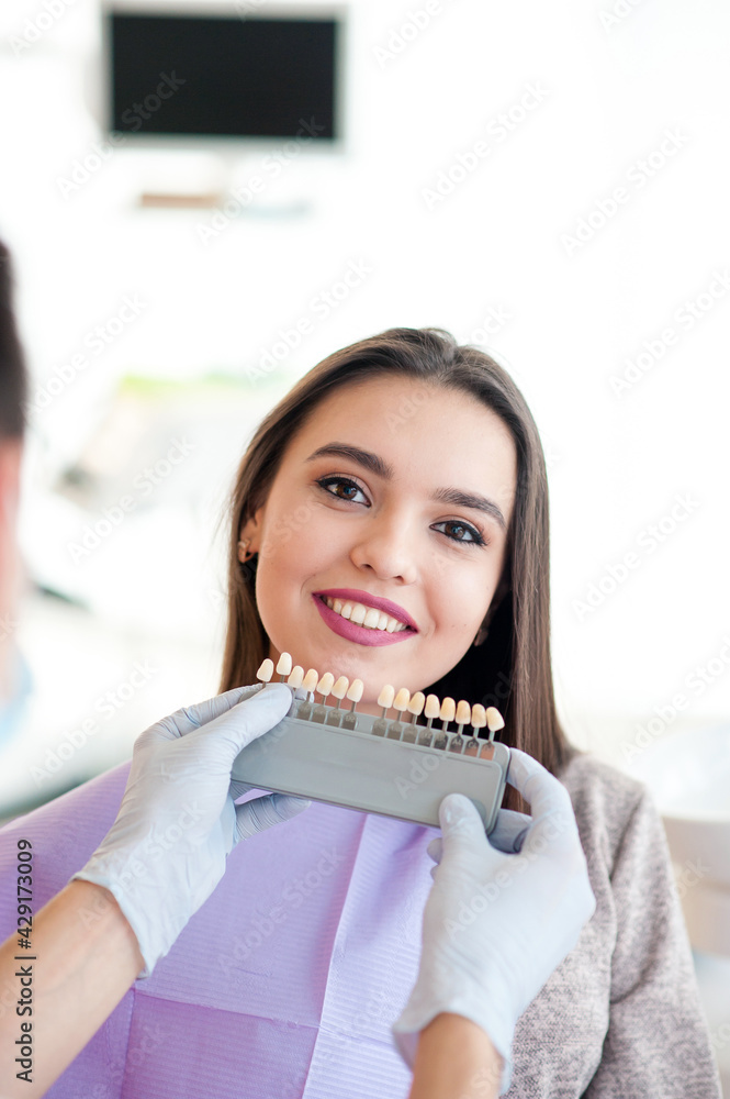 Choice of tooth color with a special scale. Dentist select a shade of