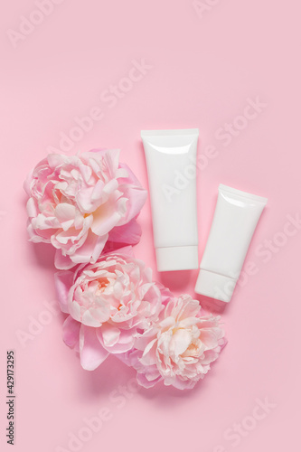 Top view composition of white plastic tubes for cosmetic products placed on pink background. Copy space