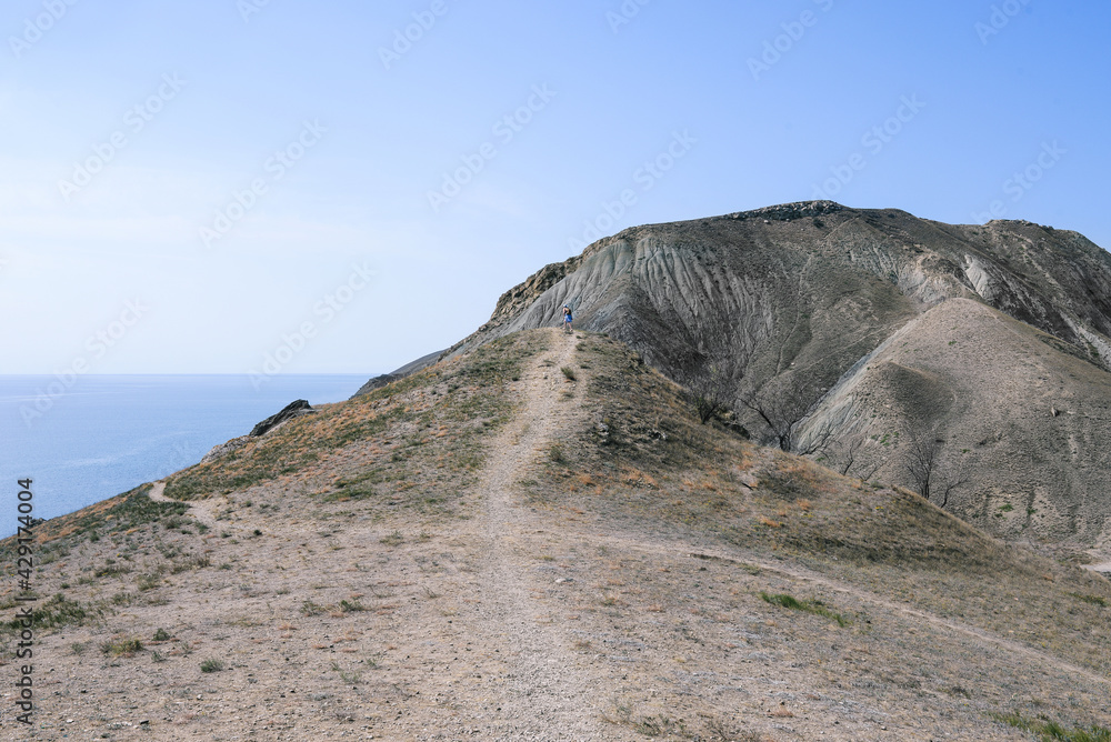 Sandy mountains and blue sky. High mountains with trails. Hiking and trekking in the mountains. Adventure and travel concept. Nature background