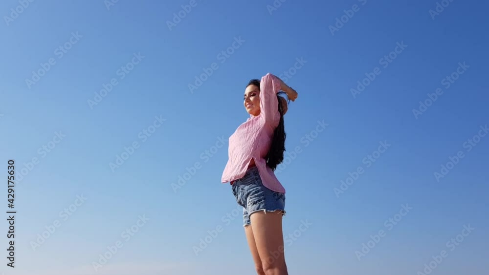 Young Woman with Long Beautiful Hair and Warm Weather. Sun is Shining and Sky is Blue. Young Woman with Long Beautiful Hair and Warm Weather. Sun is Shining and Sky is Blue.