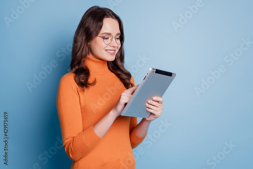 Profile photo of happy business lady hold ebook look screen read study posing on blue background photo