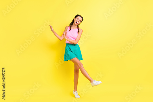 Full size photo of optimistic cool brunette lady dance wear pink top blue skirt isolated on vivid yellow color background