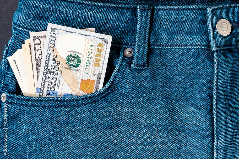 Banknotes sticking out of the front pocket of blue jeans. Close-up. Banknotes sticking out of the front pocket of blue jeans. Close-up.