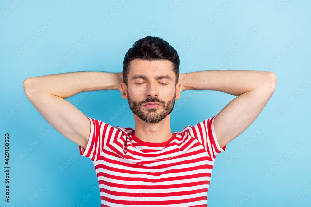 Top above high angle view of calm sleepy man hold hands behind head weekend isolated on blue color background Top above high angle view of calm sleepy man hold hands behind head weekend isolated on blue color background