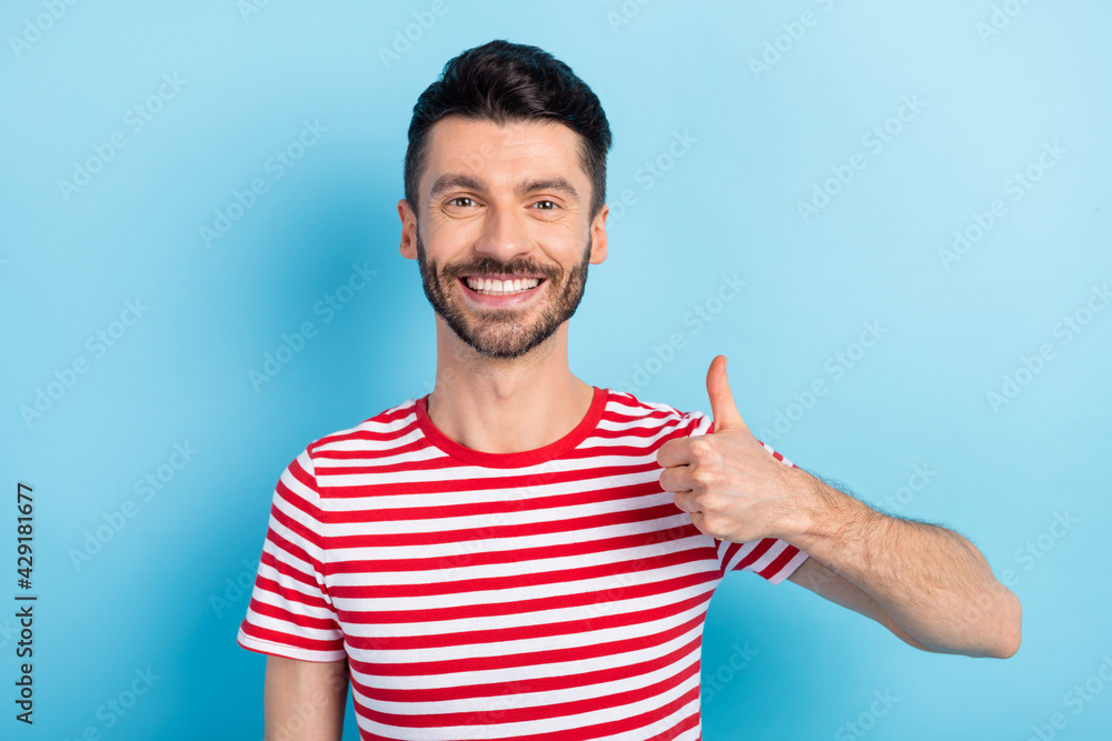 Photo of attractive cheerful young guy wear red smiling showing thumb up isolated blue color background Photo of attractive cheerful young guy wear red smiling showing thumb up isolated blue color background