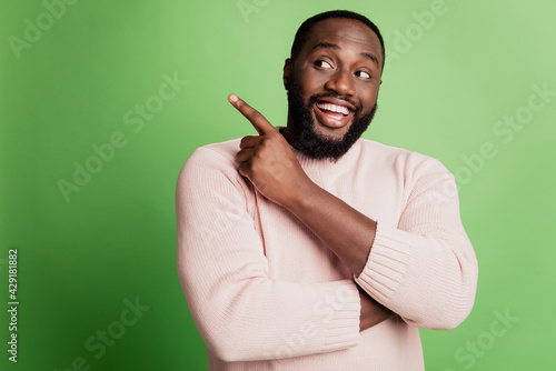Photo of positive man point finger side look empty space wear white shirt over green background