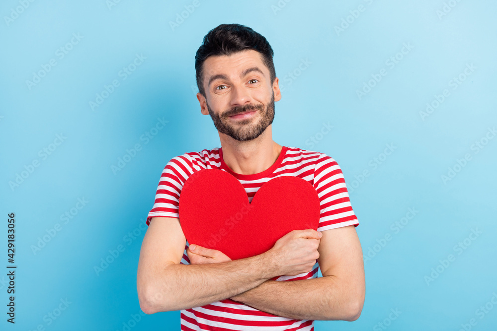 Photo of pretty charming young guy wear red outfit hugging big paper red heart isolated blue color background Photo of pretty charming young guy wear red outfit hugging big paper red heart isolated blue color background