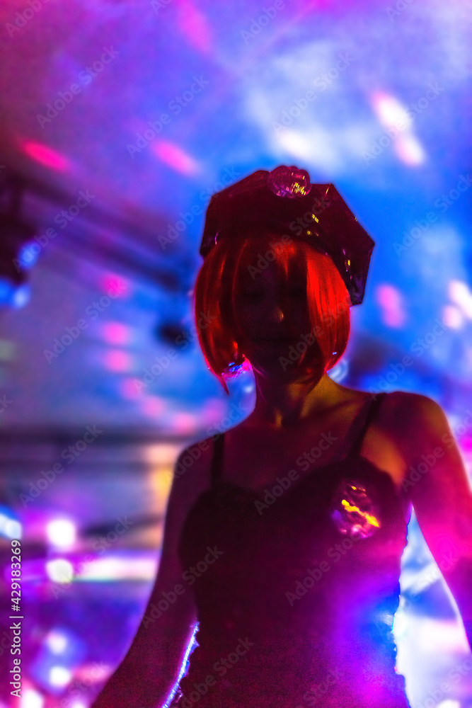 defocused background with bokeh lights in pink violet colors in a disco club with dancing woman in policewoman dress and red wig. defocused background with bokeh lights in pink violet colors in a disco club with dancing woman in policewoman dress and red wig.