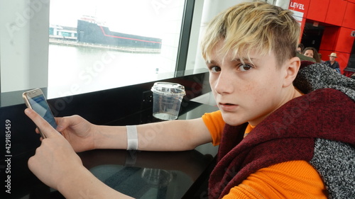 Photos Defiant Blond Teen Using Cell Phone at Counter