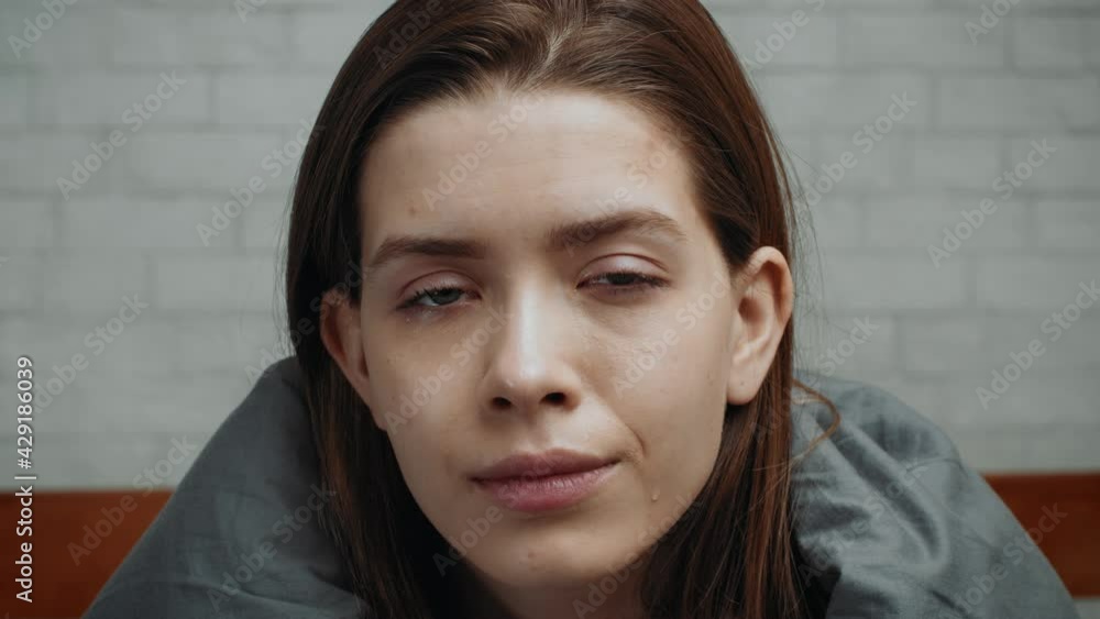 Portrait Of Depressed Woman Looking At Camera Sitting In Bedroom Portrait Of Depressed Woman Looking At Camera Sitting In Bedroom