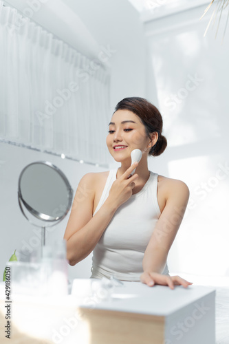 beutiful asian woman doing skin treatment her self at home. galvanic facial photo