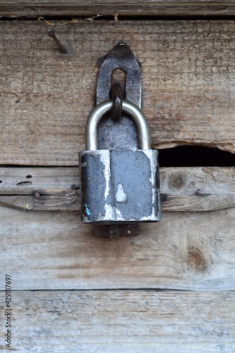 vintage lock on a rusty loop on a wooden background, copy space, concept of authentic objects