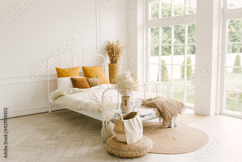 Beautiful light interior in Scandinavian style, white bed with window decoration
