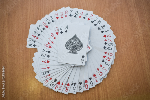 Playing cards on wooden background kept in circular manner with Ace of spade card on top, Casino, Gambling , playing cards, lifestyle, concept background