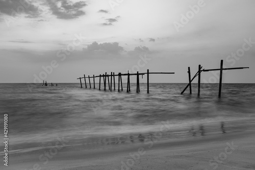 sunset over the beach with ruin pier, Pilai beach, Thailand photo