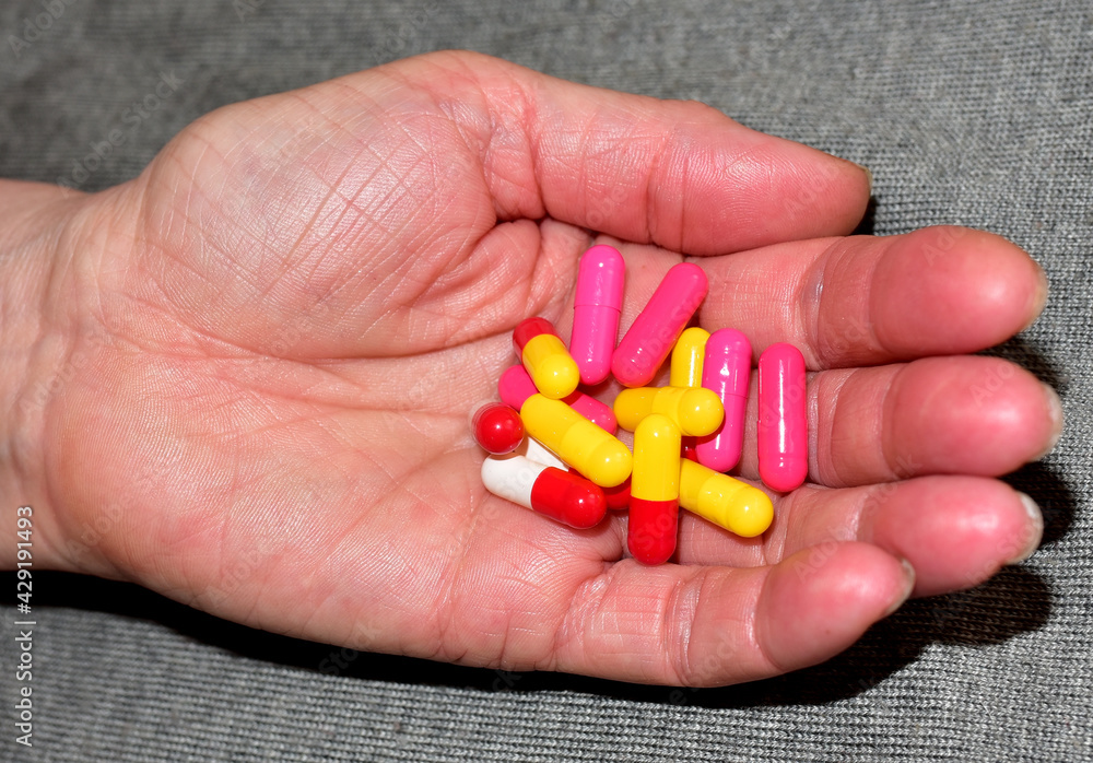 Pills in capsules in woomen hand. Medicine grade pharmaceutical tablets. Medical pill for maintaining and improving health. Grandma takes pills. Antidepressant addiction and depression concept. Pills in capsules in woomen hand. Medicine grade pharmaceutical tablets. Medical pill for maintaining and improving health. Grandma takes pills. Antidepressant addiction and depression concept.