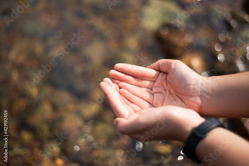 two hands holding water © Nattanon