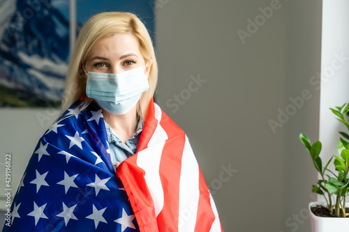 Blonde girl in face mask with USA flag. photo