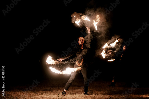Fire show. Fakir juggles with fire Poi. Night performance. Illusion of a suspended object © ksyusha_yanovich