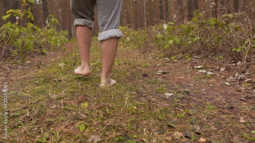 Bare Male Legs Walk Through Magical Autumn Forest, Back View. Unity of Man and Nature Bare Male Legs Walk Through Magical Autumn Forest, Back View. Unity of Man and Nature