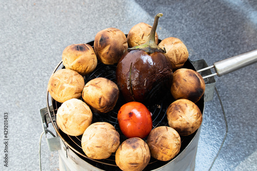 Cooking Litti Or Liti Chokha Stuffed With Chana Sattu The Famous Dish Originating From Bihar Indian Subcontinent On Direct Fire And Smoke From Tandoor Chullah Or Chulha. Isolated On White Background photo