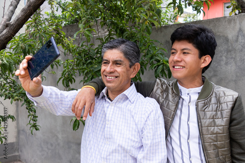 father and son smile as they take a selfie together
